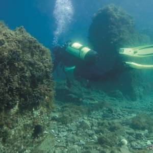 Un sub ispeziona resti archeologici nelle acque di Baia