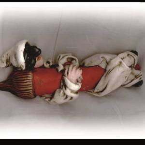 Pulcinella in terracotta abbracciato ad un corno portabene